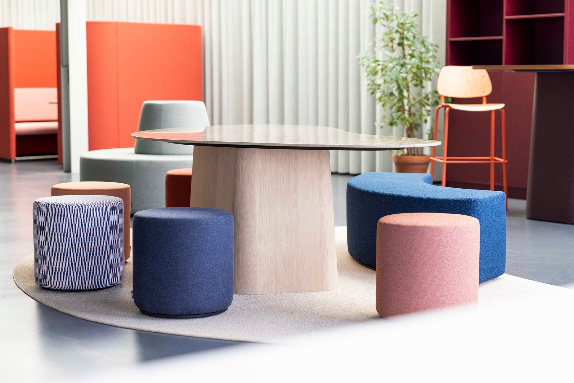 Gezellige zithoek met tafel en poefjes op een kleed in onze showroom